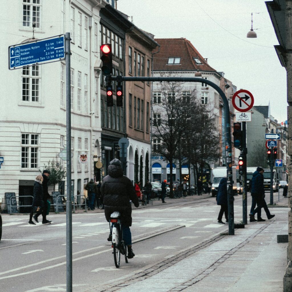 Cyclist riding through a busy intersection in Copenhagen, Denmark on a cool day.